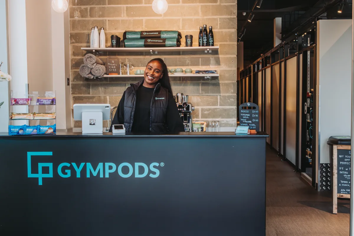 Reception area at GYMPODS Putney with staff assisting members