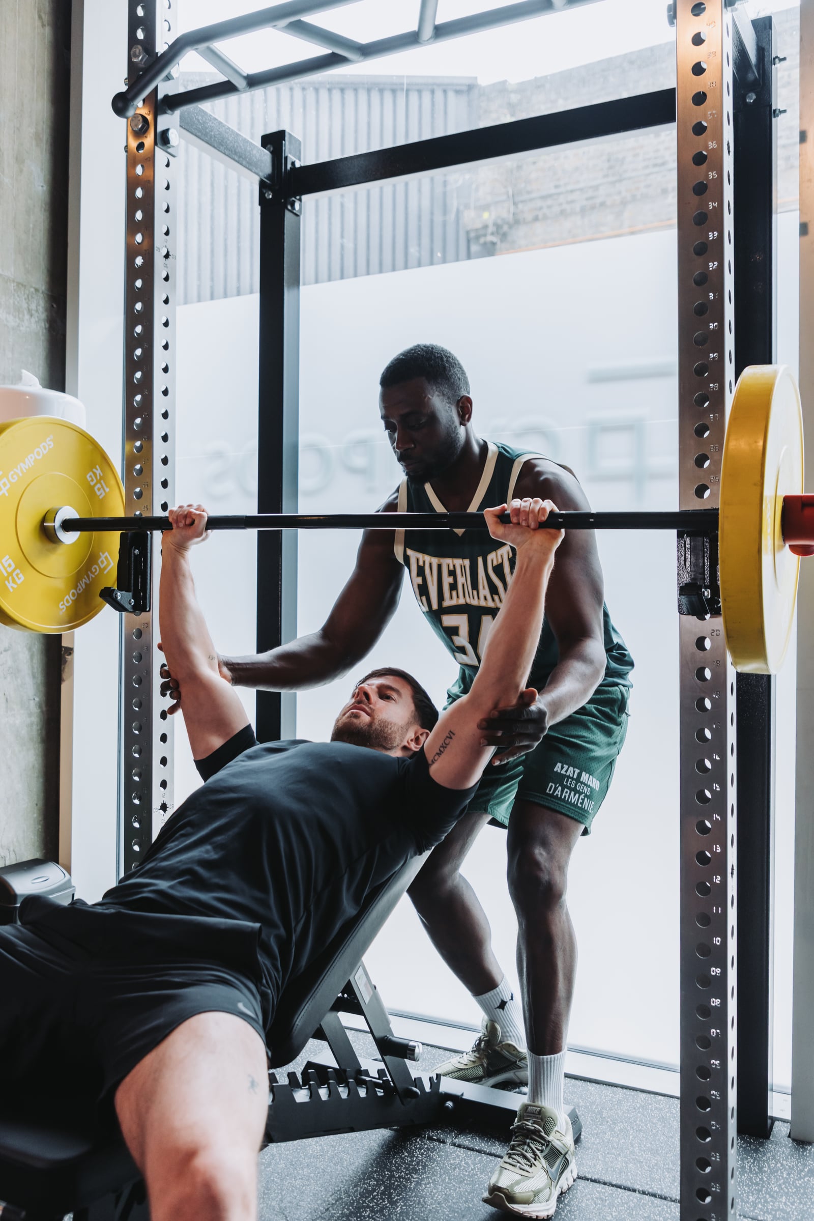 A GYMPODS member being coached by a personal trainer during a one-to-one session in a private Strength POD at GYMPODS Putney